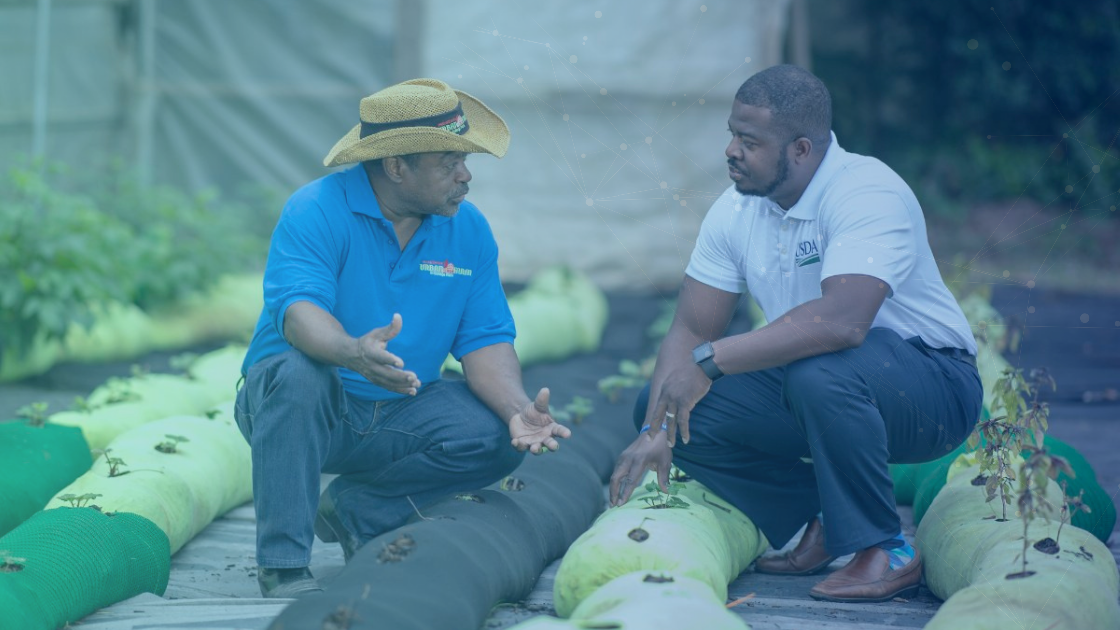 USDA Rural Development employee consulting with a community partner at an agricultural site, representing collaboration and mission support enabled by modern digital workflows.